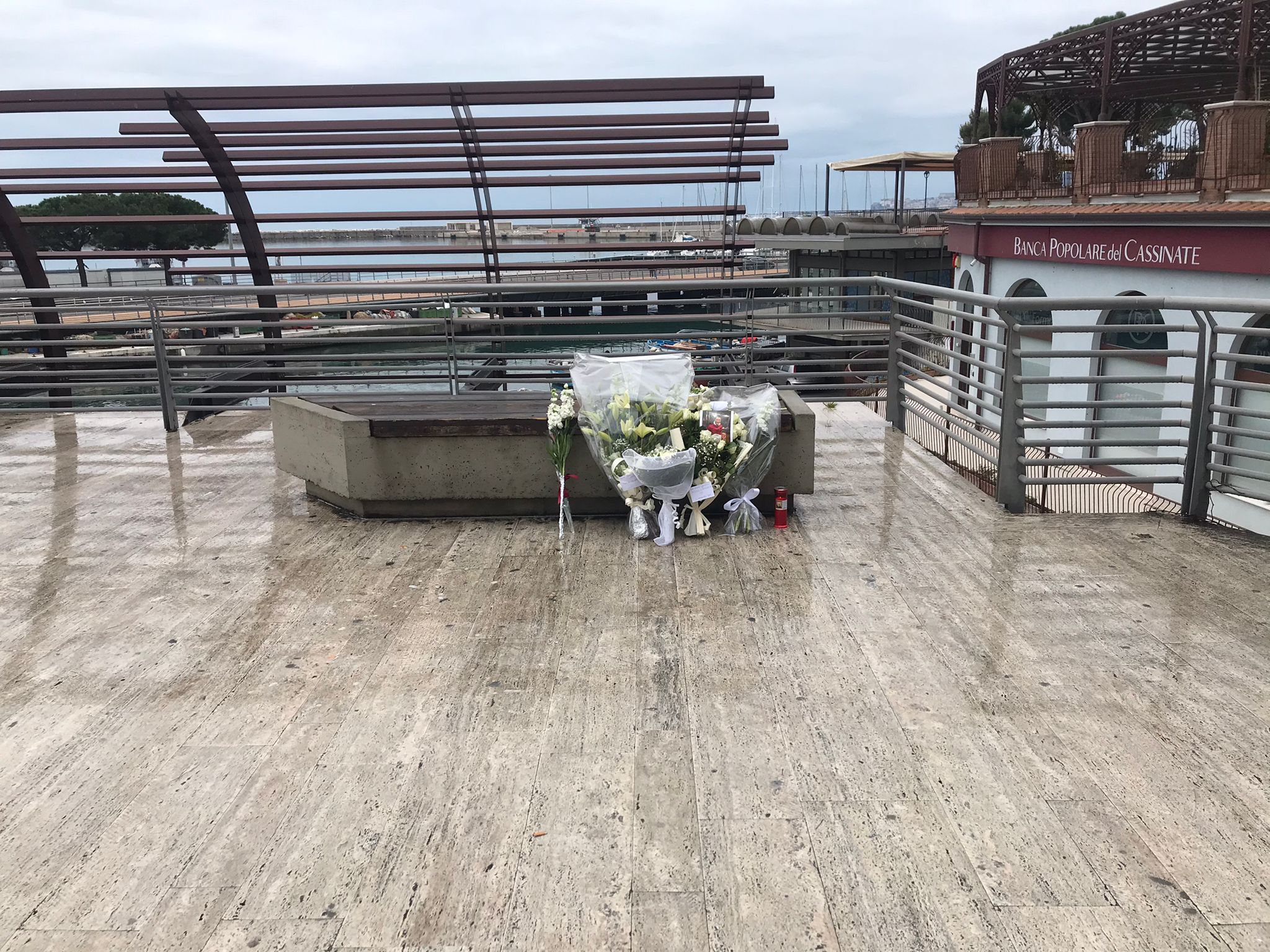 I mazzI di fiori poggiatI nel punto in cui è stato ferito a morte Romeo Bondanesi